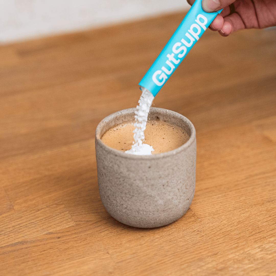 GutSupp-branded sachet being poured into coffee